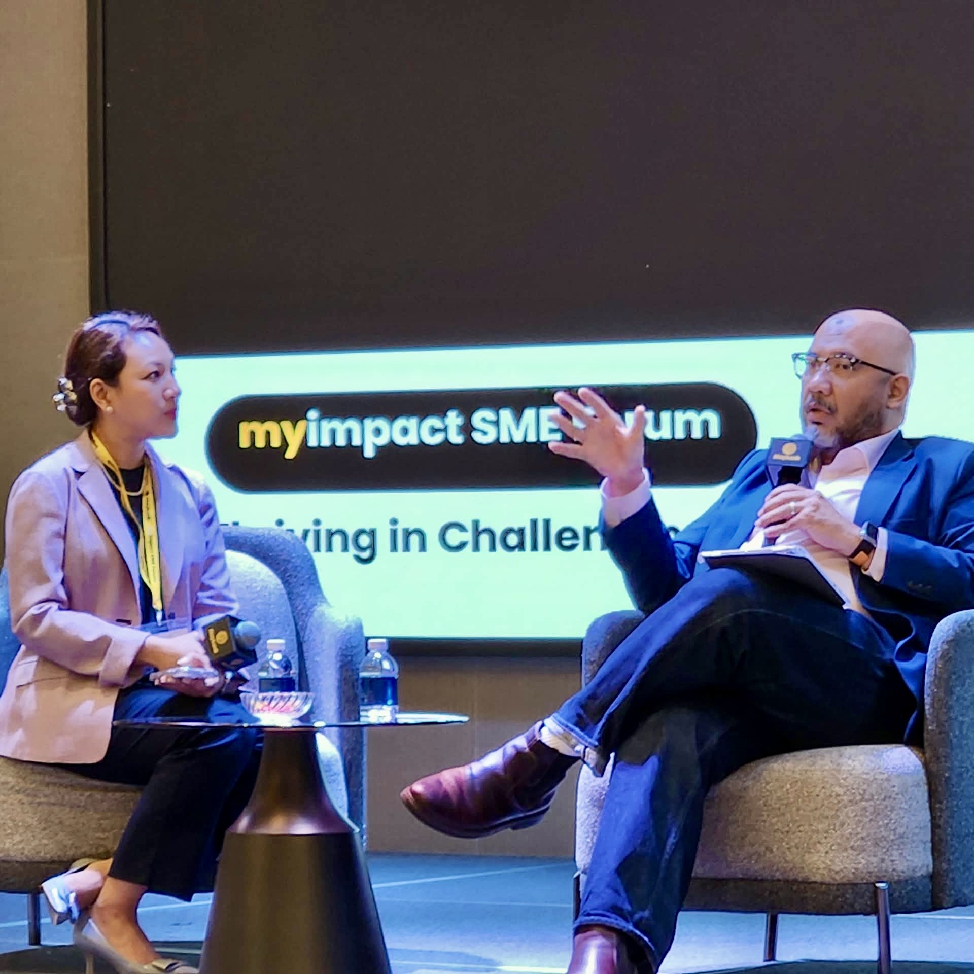 Reza Ali speaking in a fireside chat on stage at the Maybank myimpact SME Forum in Johor Bahru